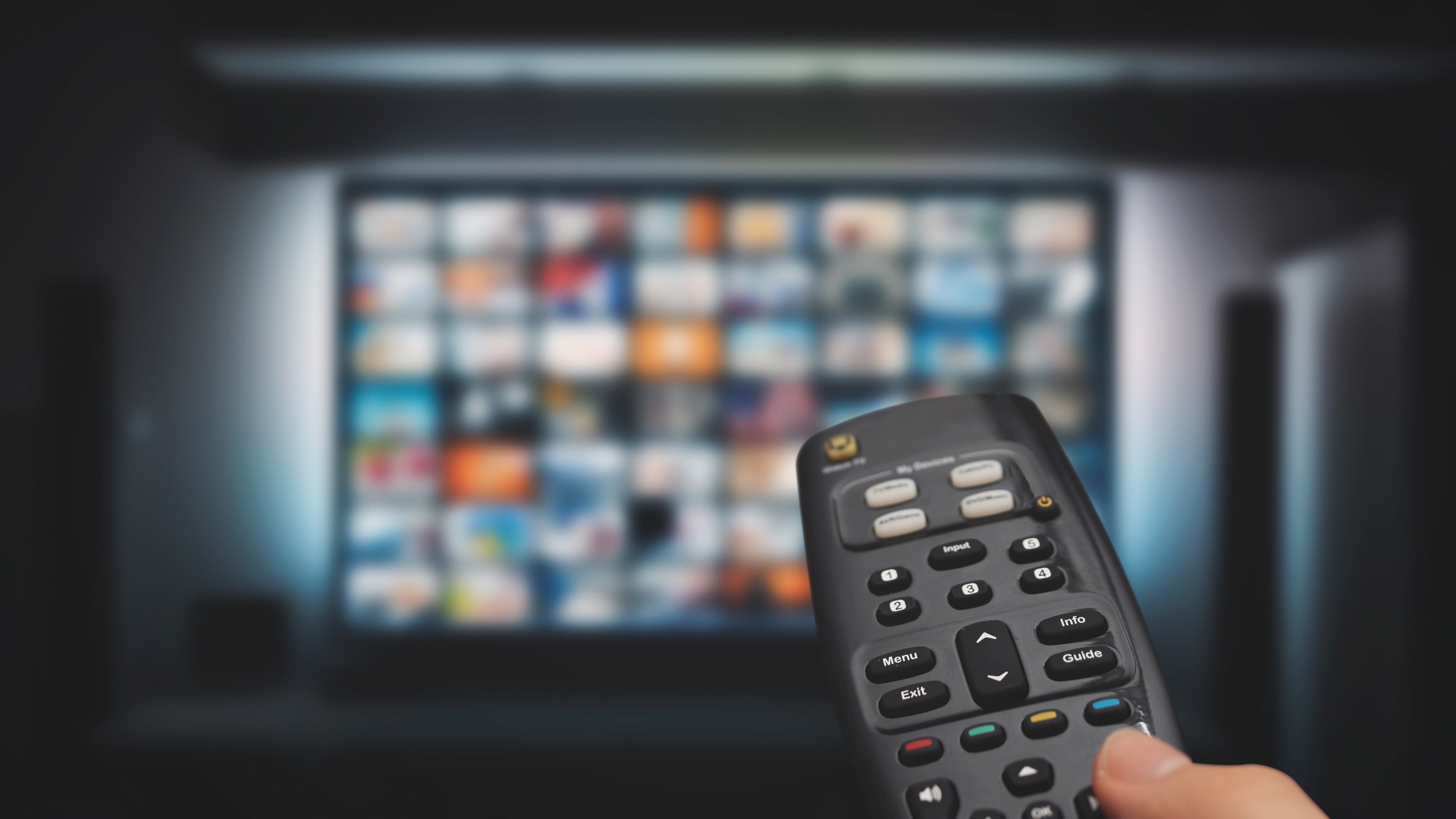VOD service on television. Man watching TV, streaming service, video on demand, remote control in hand.